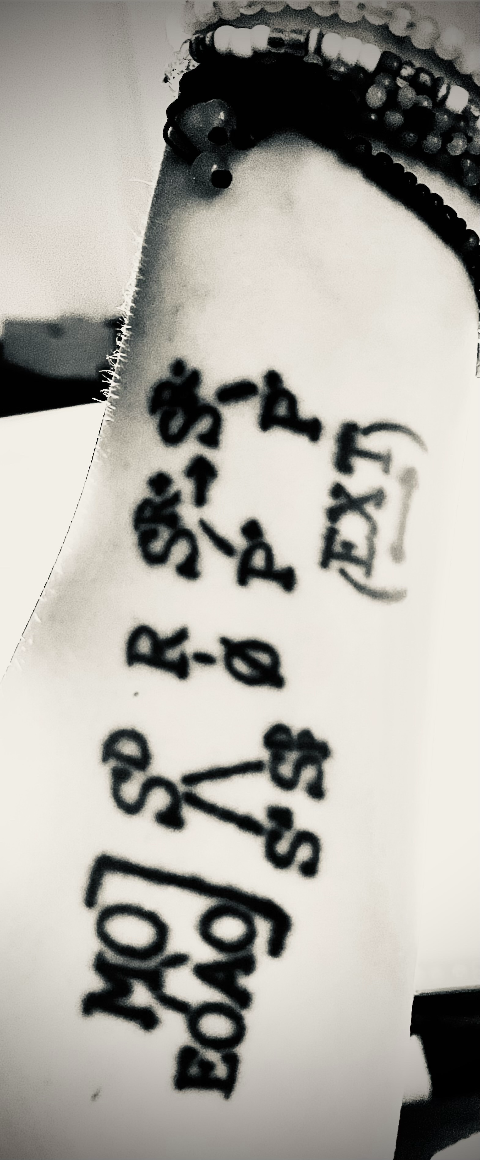 Black-and-white detail of Ashton's behavior-analysis tattoo